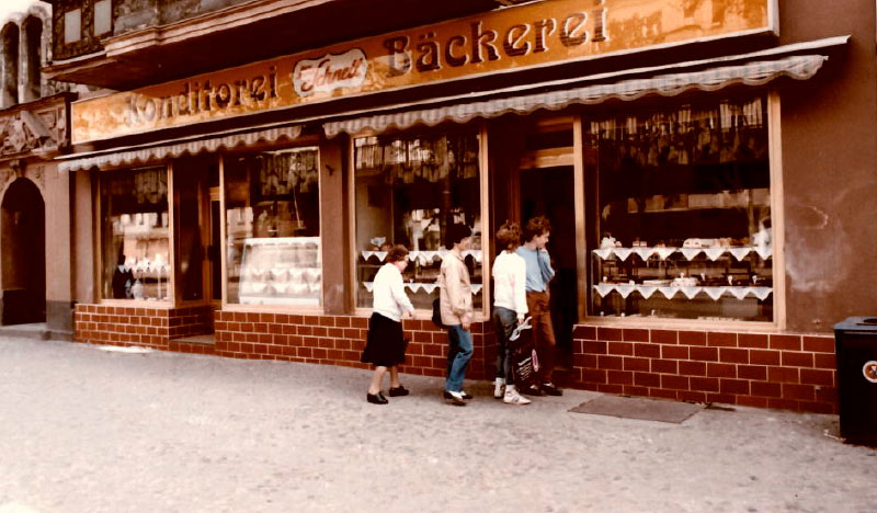 Blick auf die frühere Schnell-Bäckerei mit Kundinnen und Kunden vor dem Eingang.